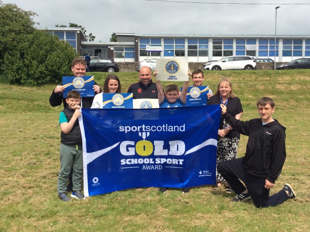 A group of children from Stirling Support Service hold a banner celebrating their gold award from sportscotland